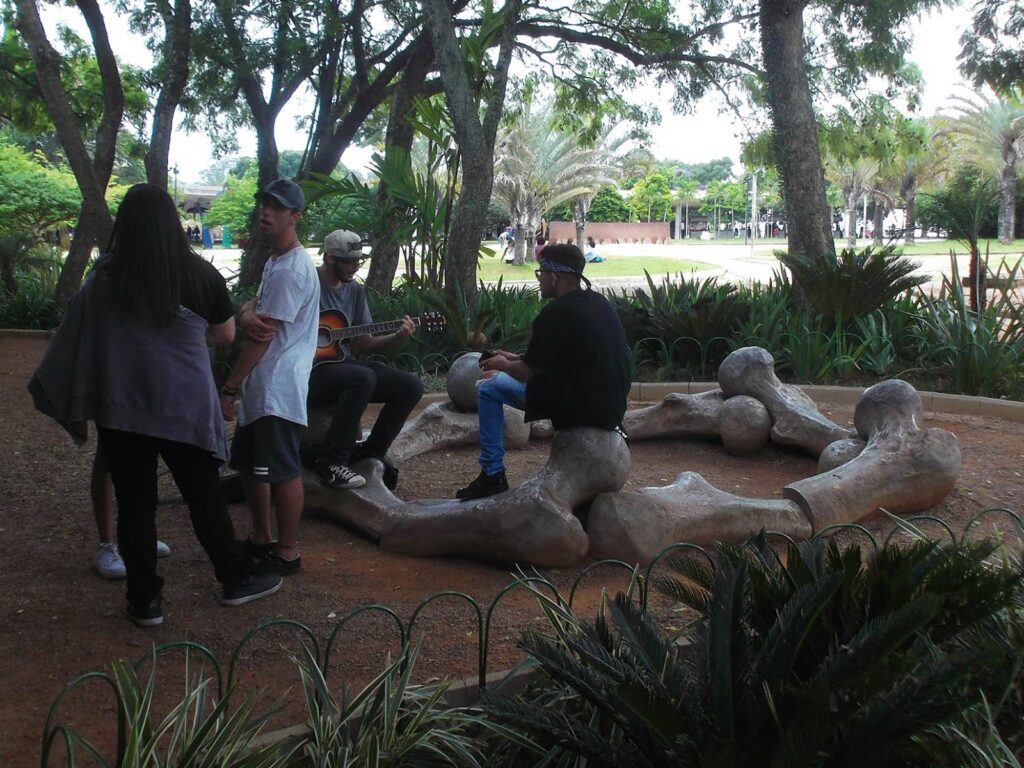 Young people hanging out on Angelo Venosa's sculpture of bones made of aluminium.