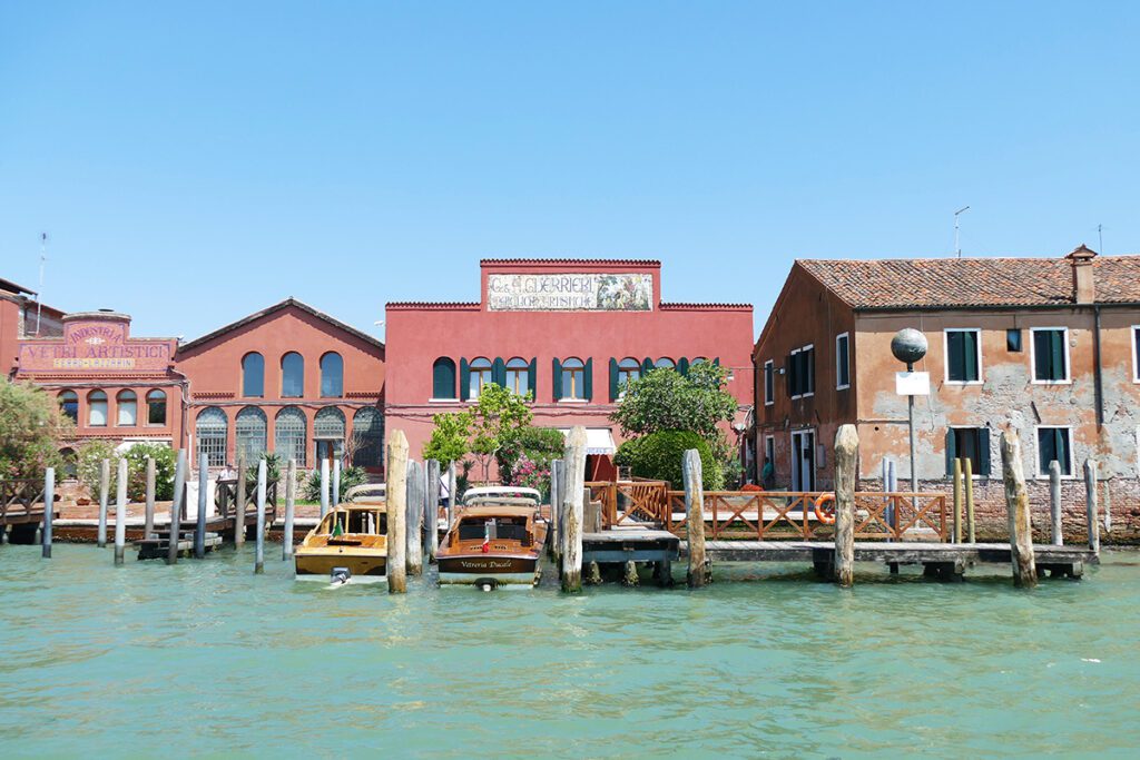 The Vetreria Ducale, adorned by a sign of Guerrieri pottery, and to the left the Ferro & Lazzarini glass factory. Murano Crystalline World