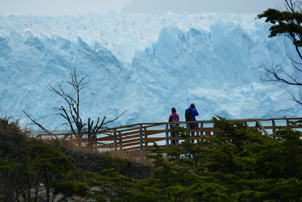 Couple taking pictures of the Perito Moreno Glacier close to El Calafate in Patagonia, Argentina