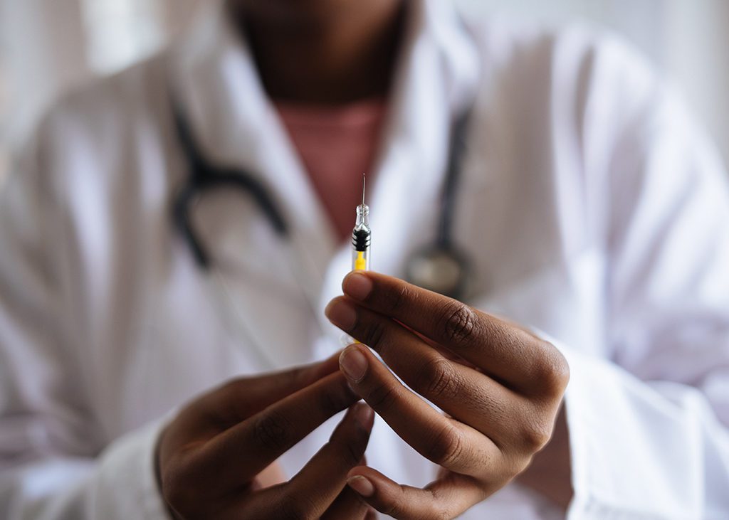 Doctor holding a syringe to show how fast travel health insurance pays off