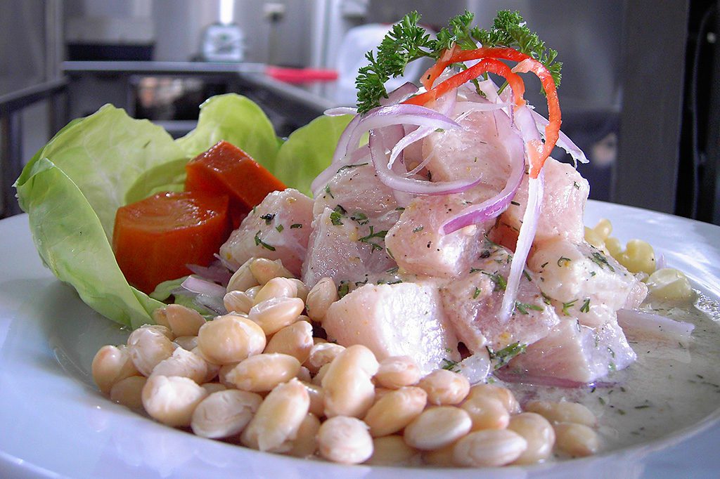 Ceviche accompanied by corn. However, there is an even better version where the corn is roasted - called cancha.
(Photo: Picanteria karol, Cebiche de corvina, cropped 2:3, CC BY-SA 4.0 )