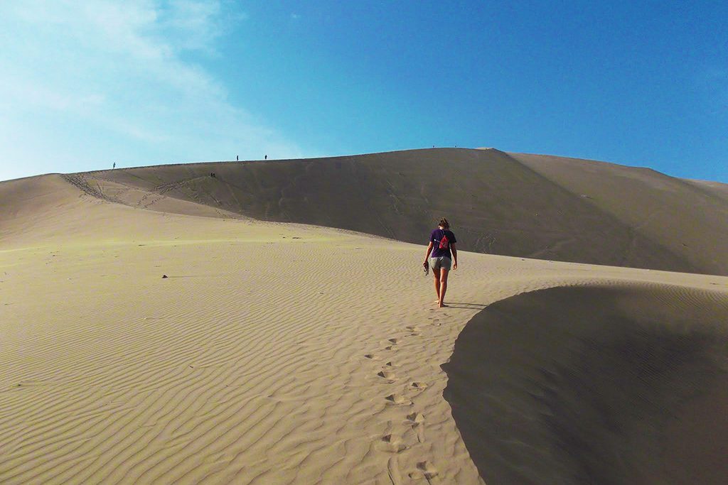 Woman hiking the desert of Huacachina, an oasis close to Ica