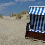 Hooded wicker chairs on the beach of Borkum West of East Frisia