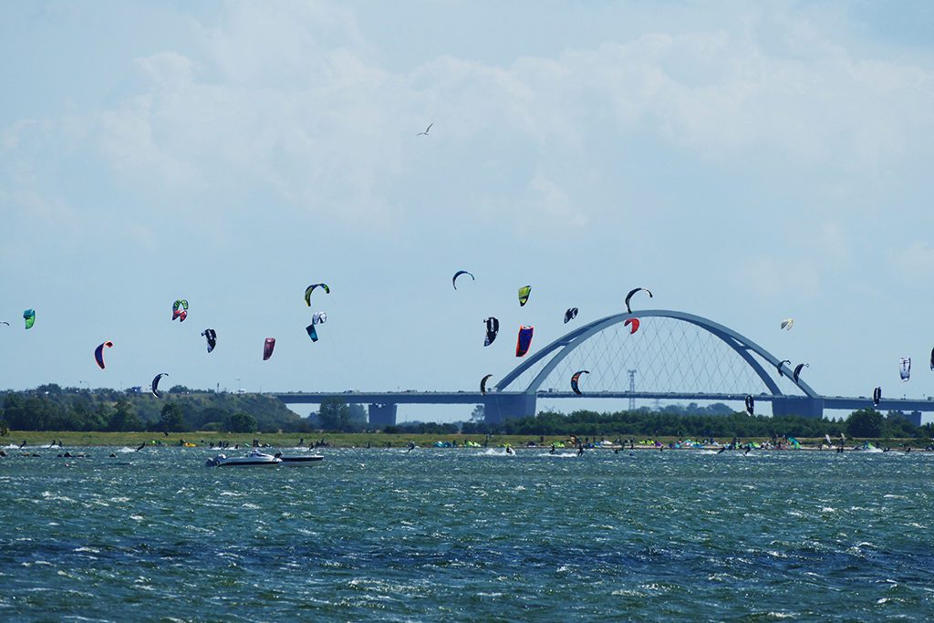 Kites'n'Surfers in all colors in front of the iconic Fehmarnsundbrücke.