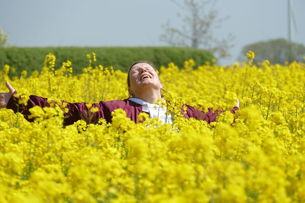 Renata Green in a field of Colza on the Island of Fehmarn in Germany