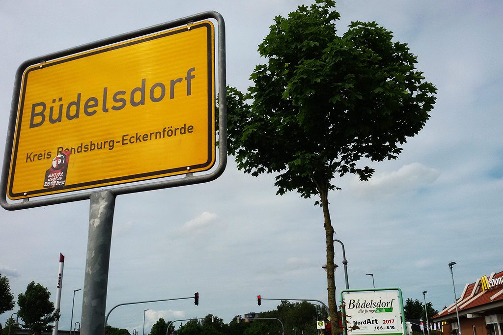 City sign Büdelsorf and a sign advertising for the NordArt2017