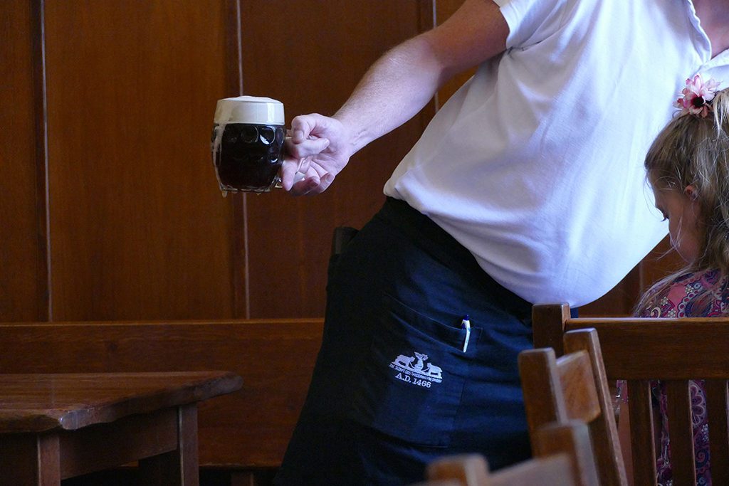 Man serving dark beer.