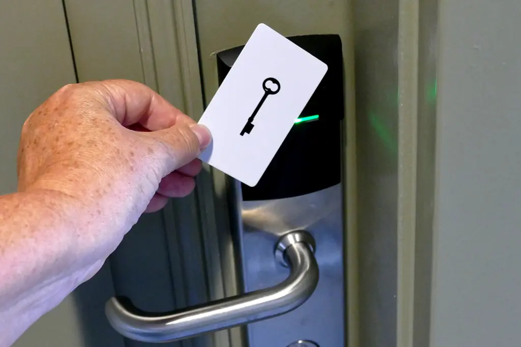 Woman opening a hotel door with a key card.