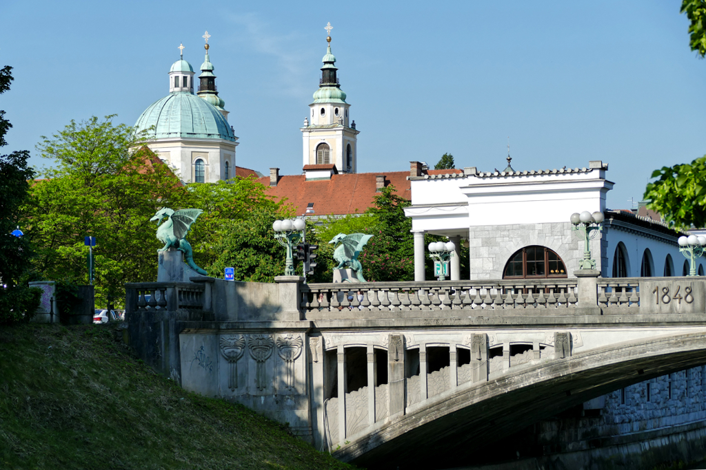 Ljubljana's Dragon Bridge, Plečnik's Arcades, and the Cathedral of Saint Nicholas in the backdrop.