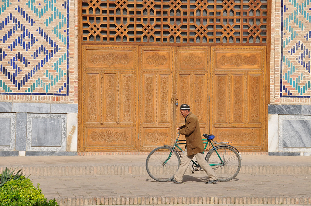 Gentleman pushing his bike through Uzbekistan,