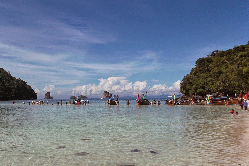 Tourists wading through the Andaman Sea, one of the must-see places in Thailand