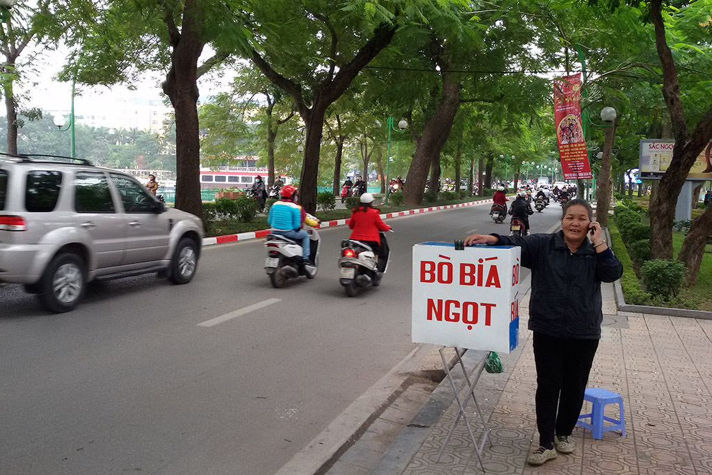 Lady selling beer on a busy road in Hanoi, gateway to the mysterious HALONG BAY