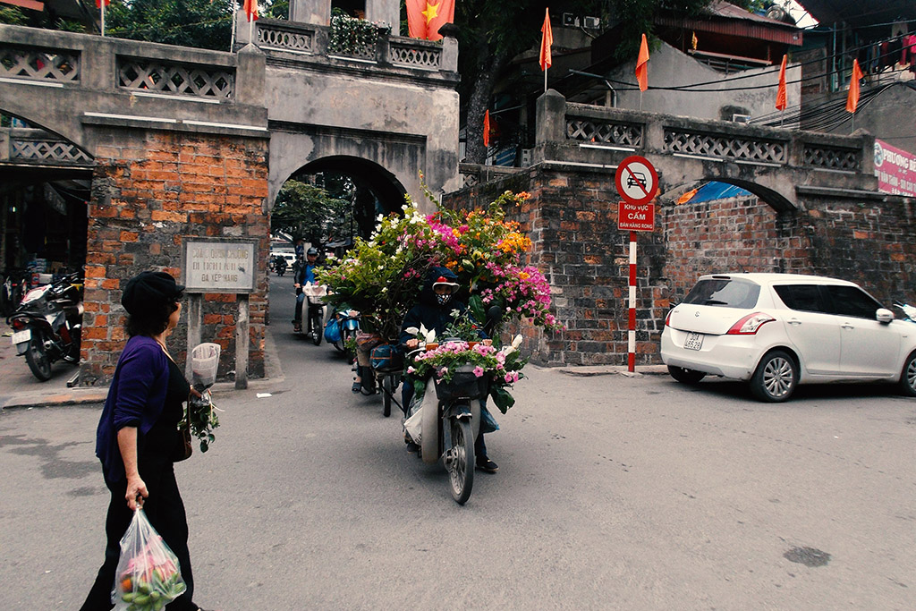 A mobile flower vendor coming through the old city gate Ô Quan Chuong from 1749. It's the only gate remaining from the Thang Long Citadel.