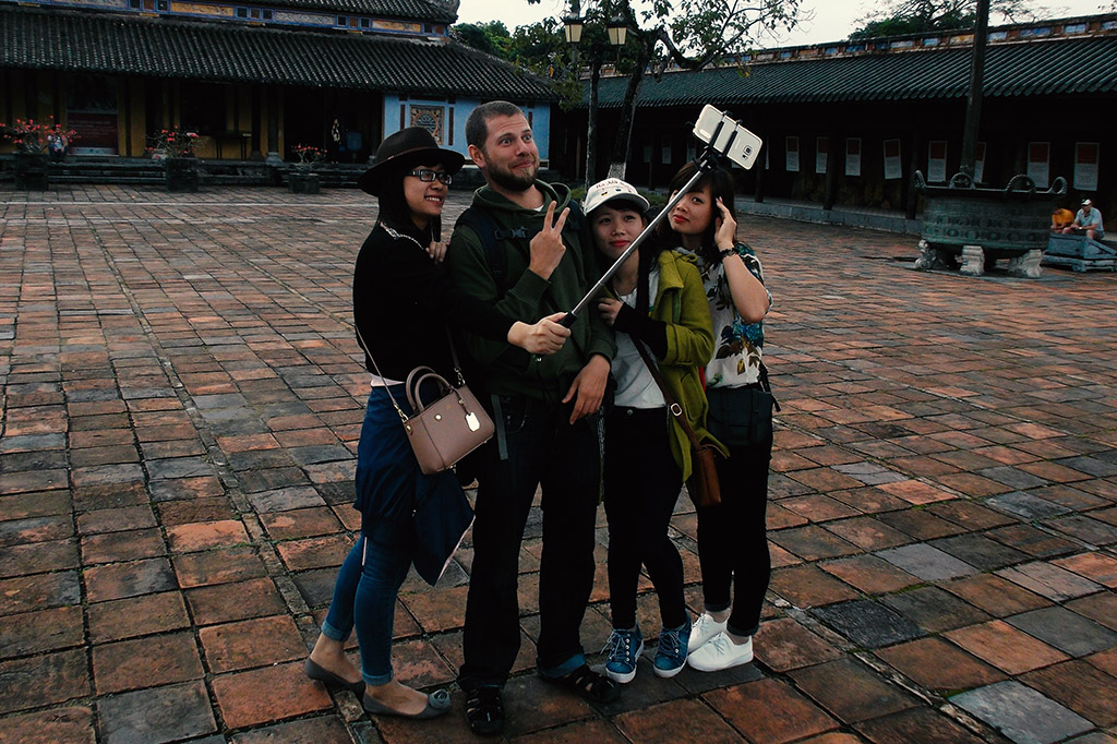 Vietnamese girls taking picture with a tourist at the Citadel in the Imperial City Hue