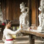 Lady placing an offering bowl at a temple.