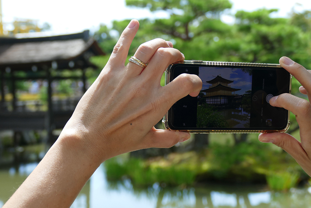 Lady taking a picture of the Golden Pavilion Kinkakuji at Kyoto