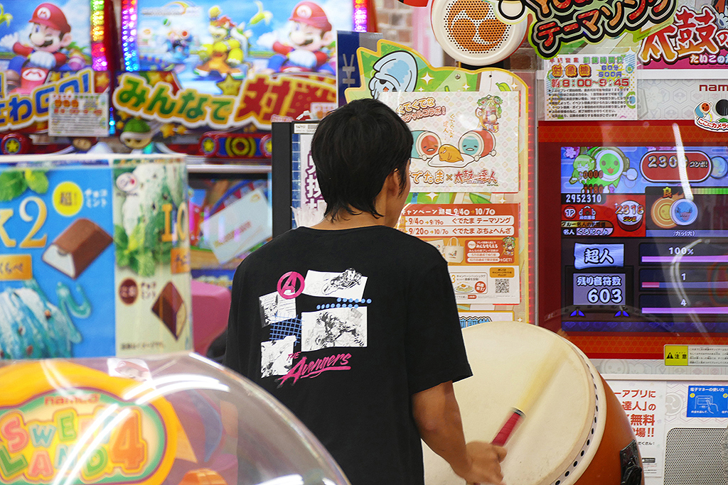 On the Osaka station's lower level: A young man drumming his heart out at the Taito Arcade.