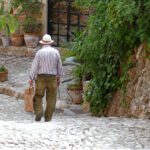 Old man walking down a cobble street in Fornalutx on the island of Mallorca