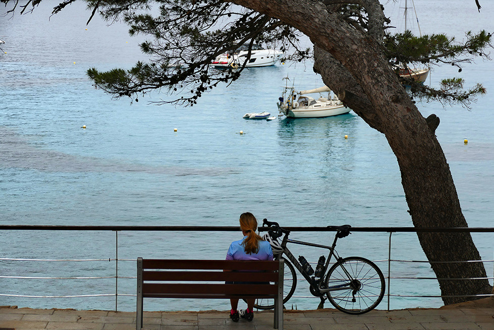 Andratx to Sant Elm Hike: Woman resting on a bench at Sant Elm 