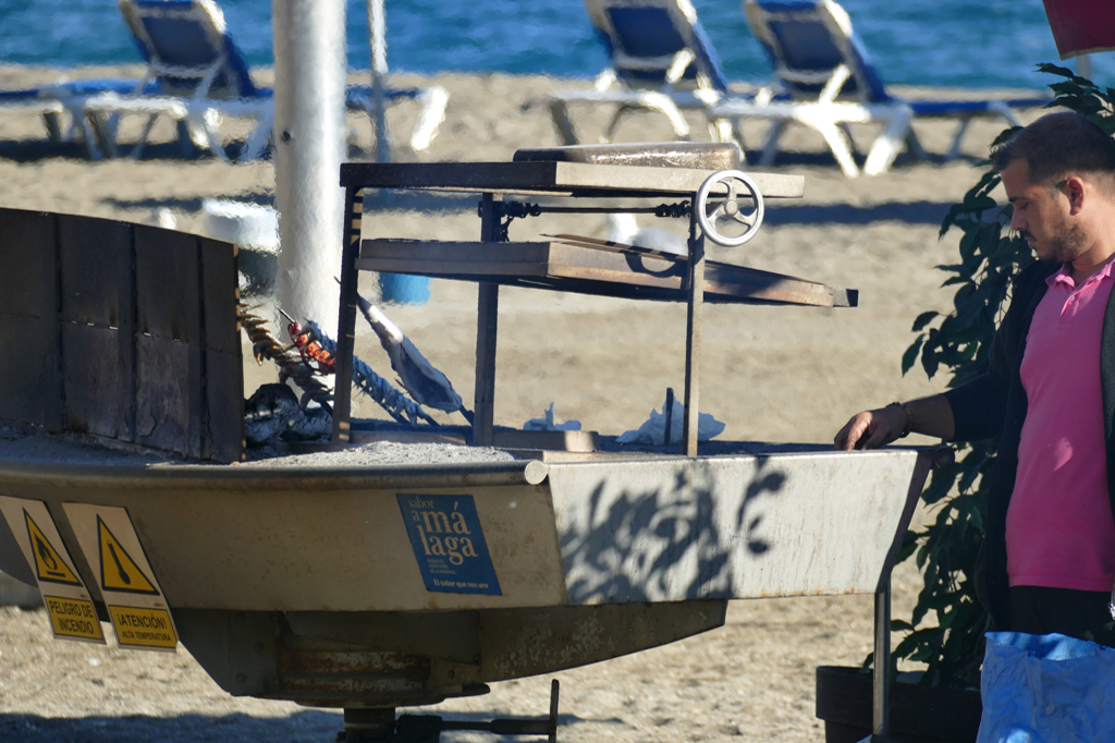 Man grilling fish on the beach in Malaga