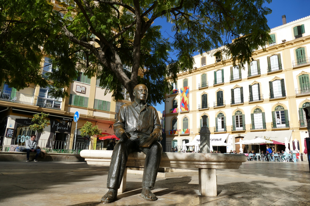 Pablo sitting on a bench in front of his birth house on Plaza de la Merced.
