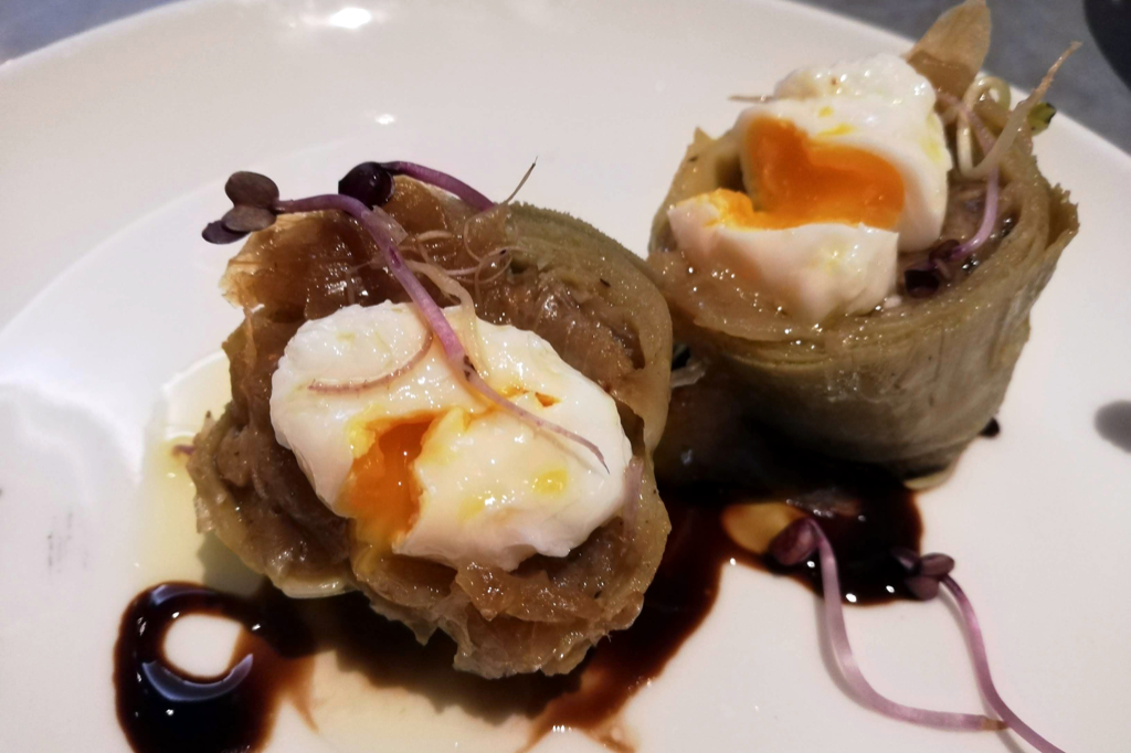 Artichoke hearts with quail eggs, caramelized onion, and truffle oil.