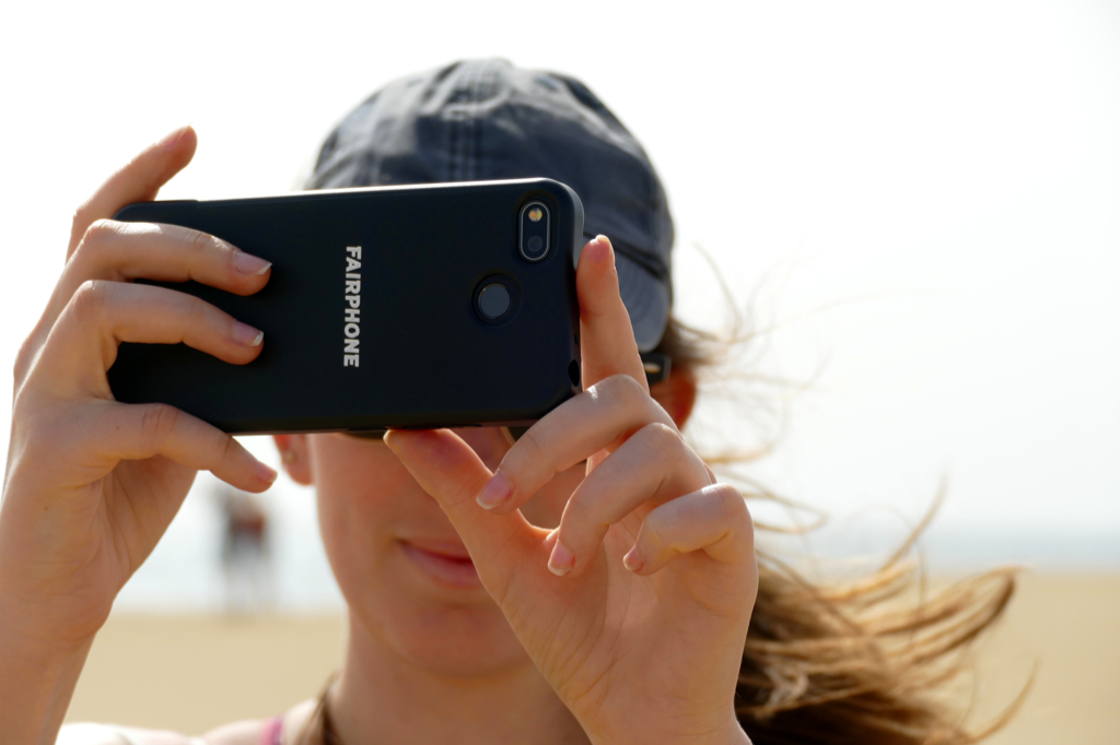 Woman holding up a fairphone in Maspalomas on Gran Canaria.