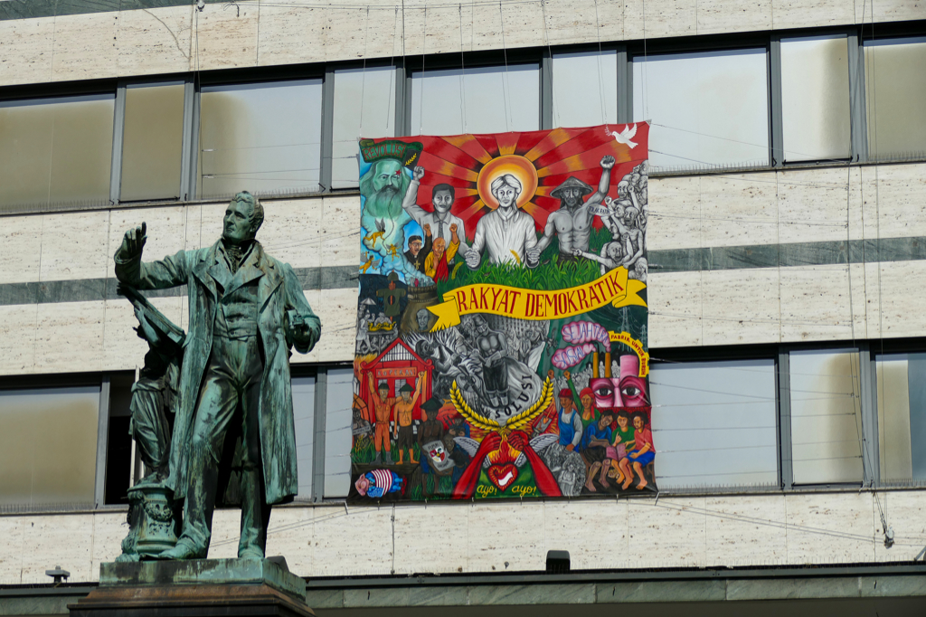 Statue of Louis Spohr and painting at a facade in Kassel on the occasion of the documenta in 2022