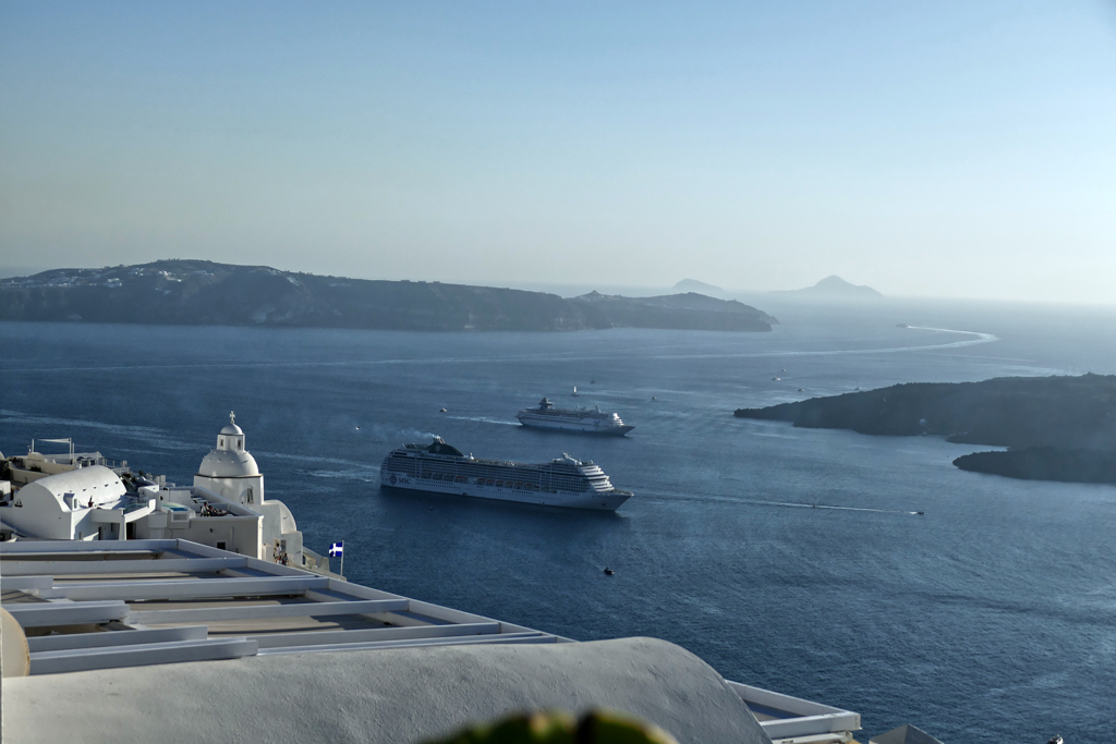 Large cruise ships anchor in the small harbor between Fira and the volcanic island Nea Kameni.