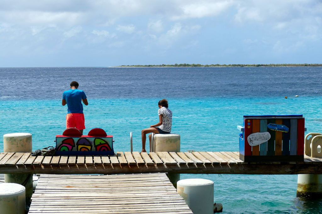 Couple on a jetty in Kralendijk in Bonaire,  illustrating the post on Island Hopping between Aruba Bonaire, and Curacao.