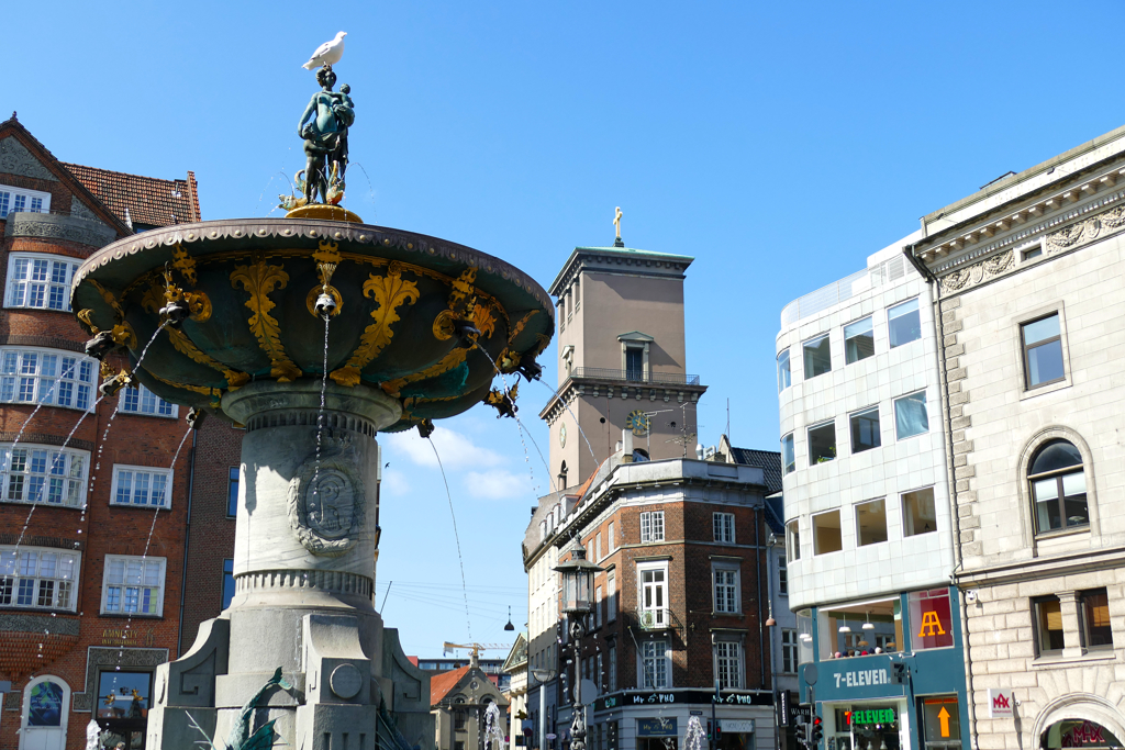 The Caritas Fountain is the oldest fountain in Copenhagen. It was built in 1608 by Christian IV and is located in Gammeltorv Square. In the beck, you can spot the austere tower of the Vor Frue Kirke.