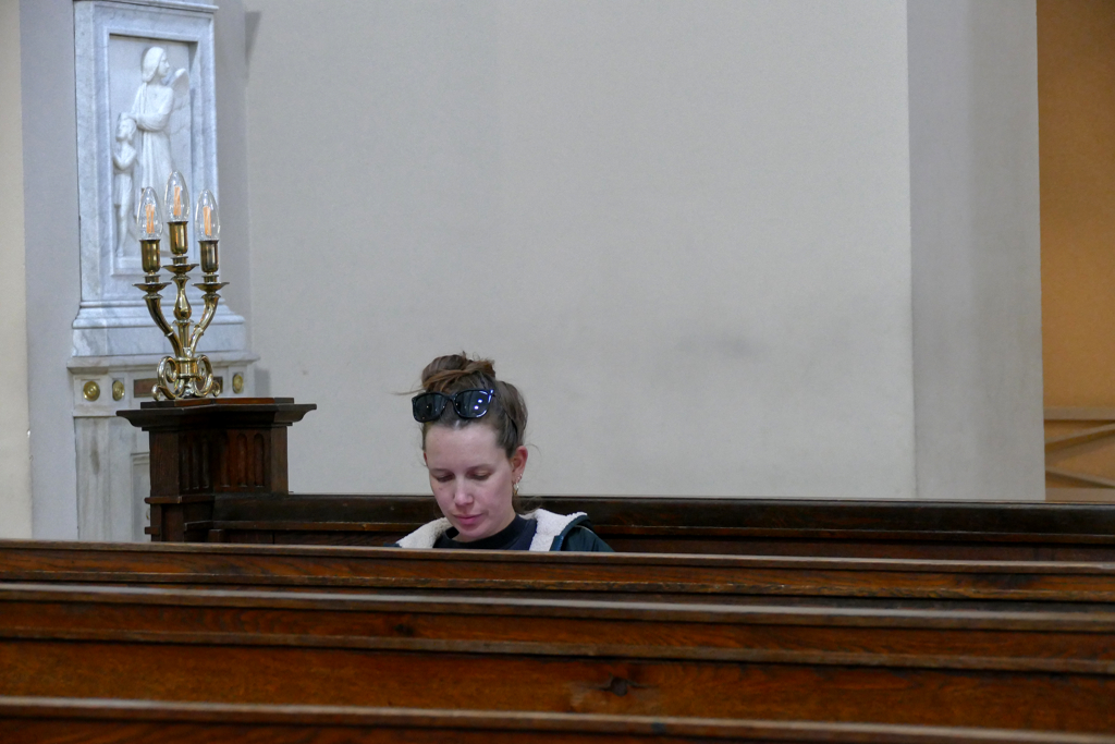 Young woman sitting on a bench in a church in Copenhagen.