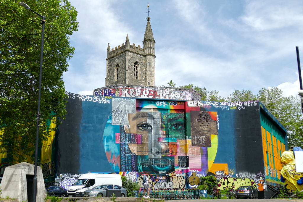 Street Art Bristol Nelson Street Stokes Croft: Mural by HazardOne with the St Mary Le Port Church in the backdrop.