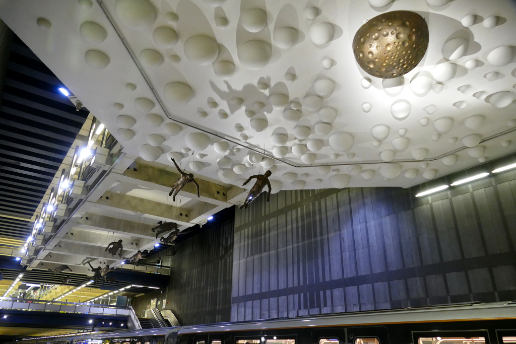 16 x Icarus by Paul van Hoeydonck flying above the platforms of the station Comte de Flandre