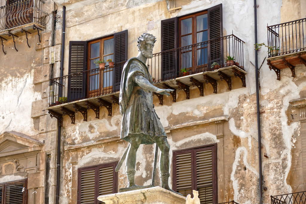 Statue of Charles V in the center of the flawed buildings surrounding the historic Piazza Bologni.