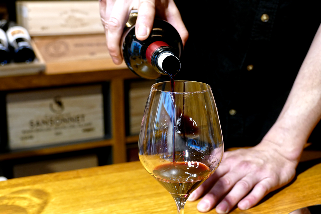 Man filling a glass with wine.