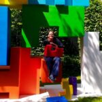 Renata Green sitting in the art installation Childhood Block by LEUNG Hongman.