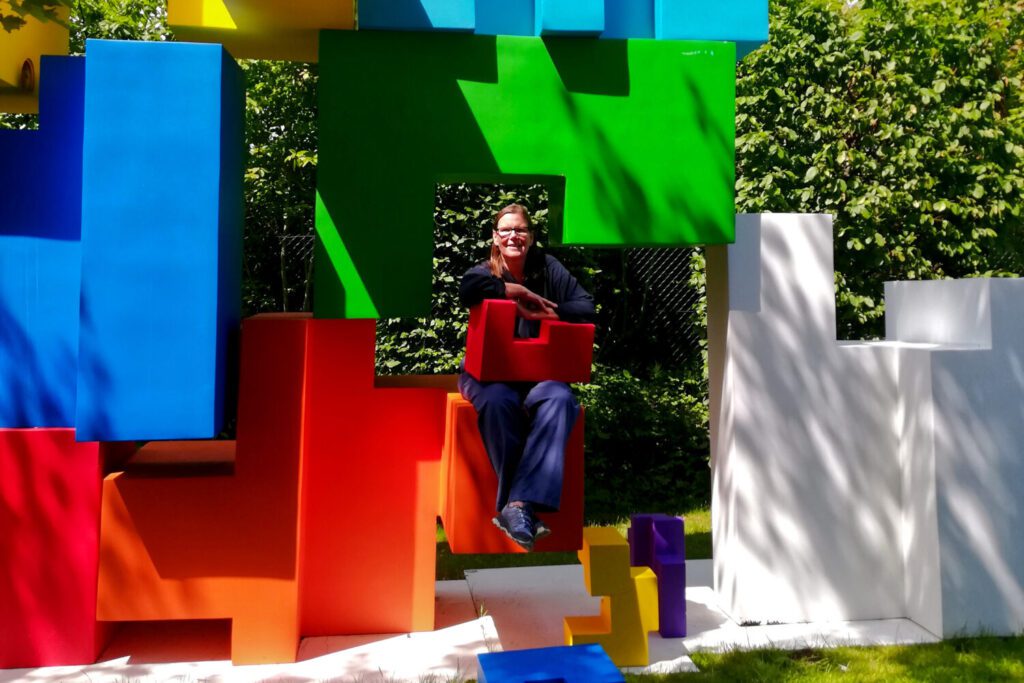 Renata Green sitting in the art installation Childhood Block by LEUNG Hongman.