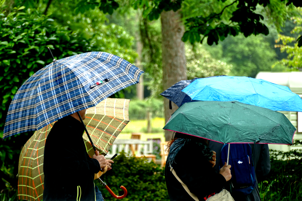 People with umbrellas at Lower Slaughter.
