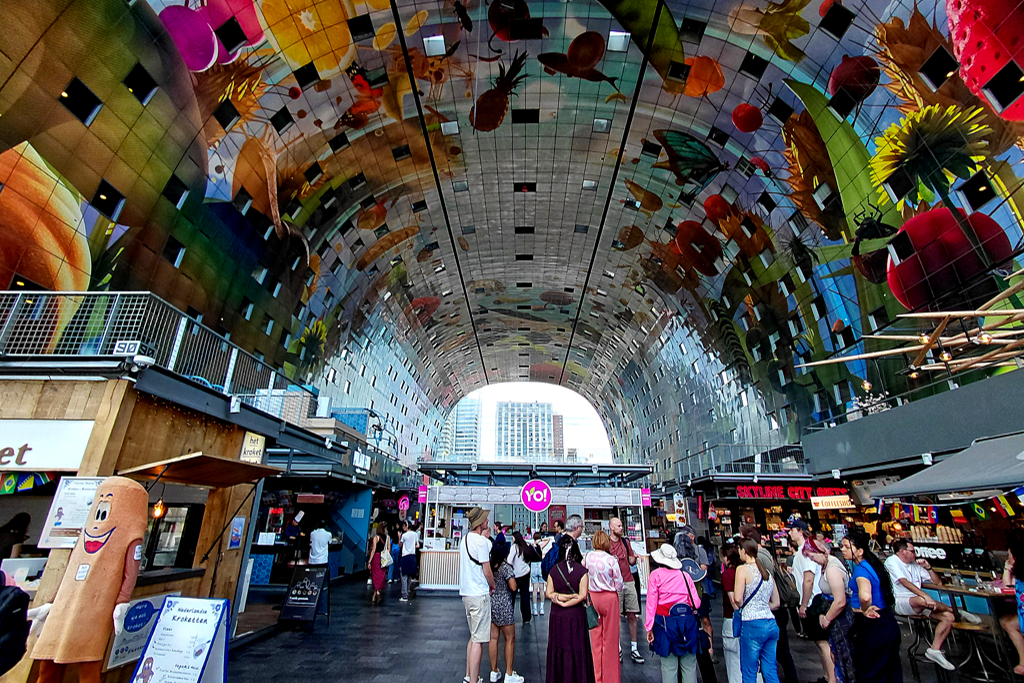 Inside the Markthal, the gigantic ceiling installation by Arno Coenen and Iris Roskam called Horn of Plenty depicts oversized fruits,'n'flowers.