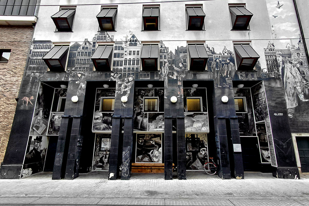 Scenes and characters from the Flemish novel Kaas by Willem Elsschot are combined with historical house facades on the exterior of the Hendrik Conscience Heritage Library.