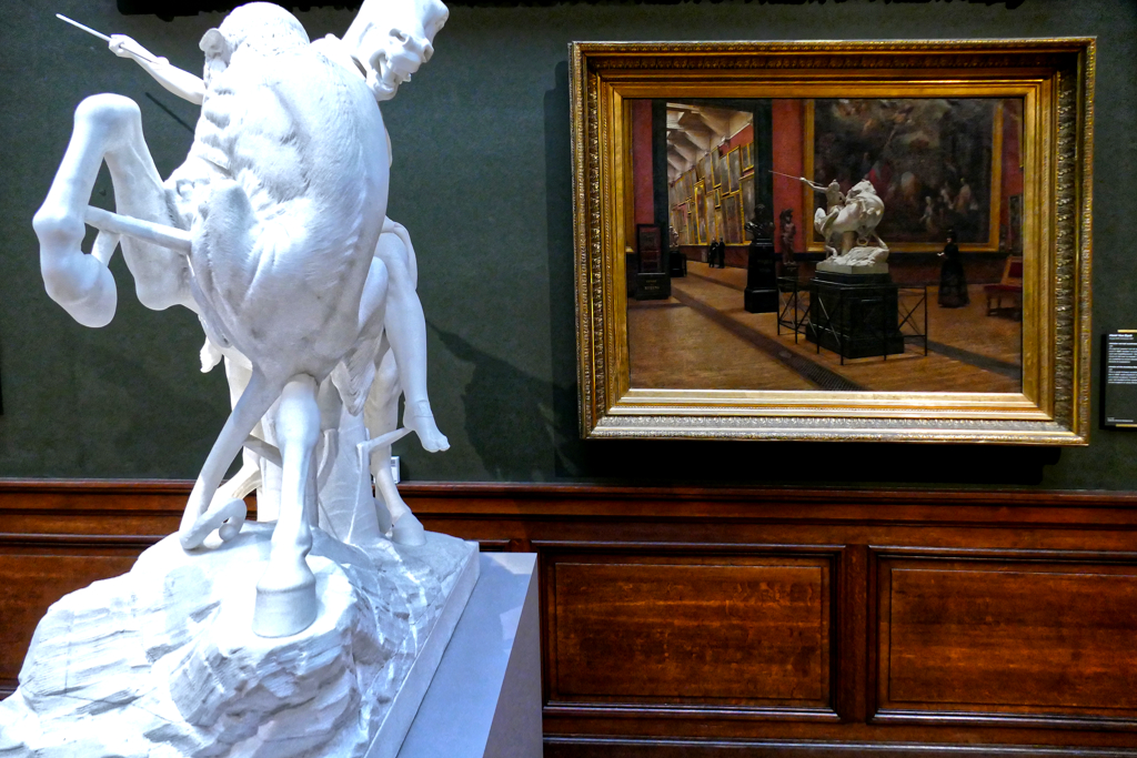 Double the impact: the marble sculpture *Amazon Fighting a Panther* by German sculptor August Kiss. Behind it, you can see it again in the painting *The Academy Museum in Antwerp* by Belgian artist Henri Van Dyck.