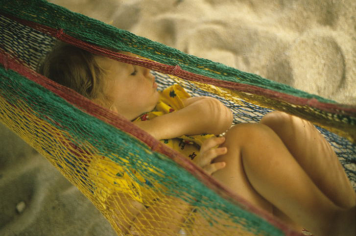 Baby sleeping in a hammock on Placencia beach in Belize