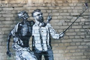 Mural of a man taking a selfie with death