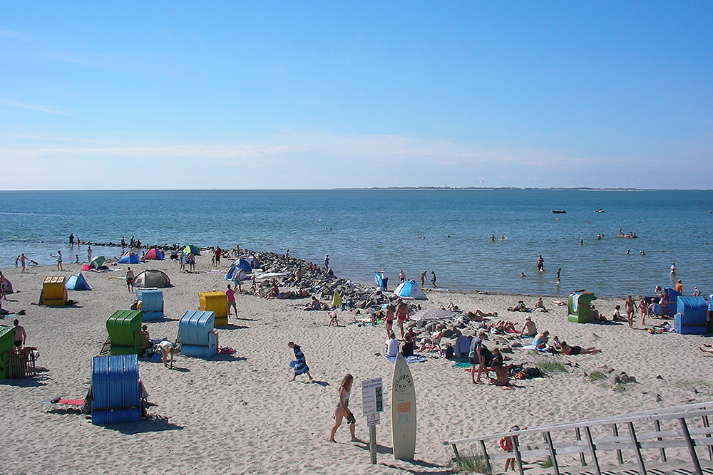 Cherishing the joys of summer. All the way in the back, you can spot the island of Amrum on the horizon. (Photo: Pincerno at German Wikipedia, Pincerno - Utersum 1, cropped to 2:3, straightened, CC BY-SA 3.0 DE)