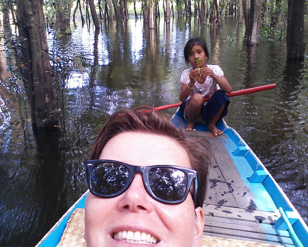 Little girl rowing a tourist through a water wood