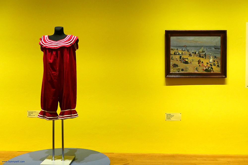 To the left, a woman's swimsuit from 1910, to the right Paul Wilhelm's painting Children at the Beach in Wyk