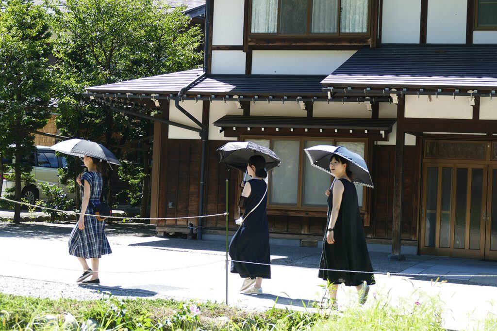 Three women carrying umbrellas against the sun in Shirakawago